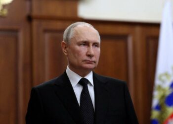 Symbolbild eines leeren Konferenzsessels mit russischer Flagge beim BRICS-Treffen, das Putins Abwesenheit verdeutlicht