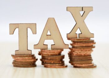 Symbolbild einer britischen Flagge neben Geschäftsunterlagen, das die Vorteile einer englischen Gesellschaft visualisiert