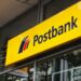 Probleme mit der Postbank: Business-Kunden reichen Beschwerden ein 2 Postbank-Filiale mit wartenden Business-Kunden, die Beschwerdeformulare ausfüllen und einreichen