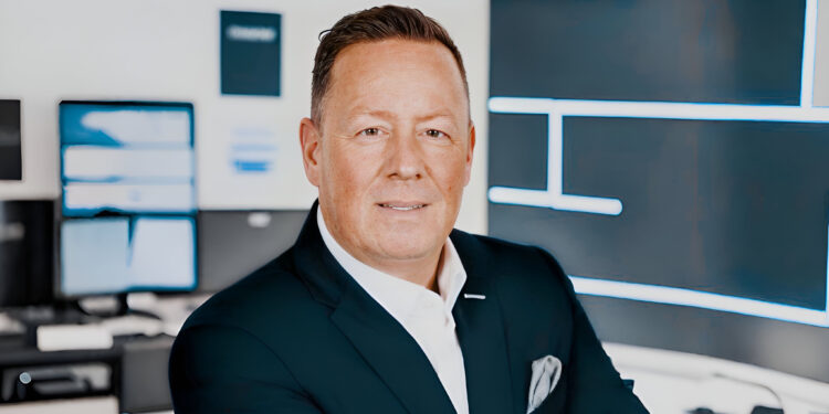 Hat Constantin Seretoulis Sorgen mit Factonet? 1 Constantin Seretoulis mit besorgtem Gesichtsausdruck vor Factonet-Logo, deutet auf mögliche Probleme hin