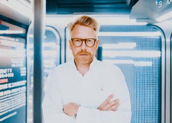 Container Investor Philipp Schober in Geschäftskleidung vor Containern im Hafen, analysiert Investitionsmöglichkeiten