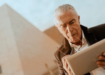 EWIV Geschäftsmodell unter der Lupe: Legale Unternehmensform oder Betrugsmasche? Symbolbild mit Lupe und Akten