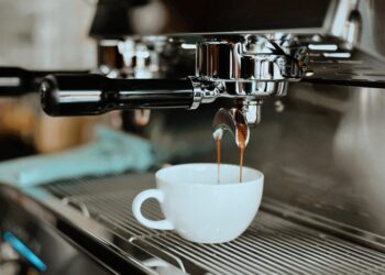 Gemütliches Interieur des Doppio Café in Hannover mit Holztischen, Ledersesseln und warmer Beleuchtung