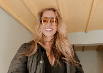 Elena Nozon, erfolgreiche Gründerin aus Hannover, lächelnd in ihrem Büro mit Laptop und Notizbuch