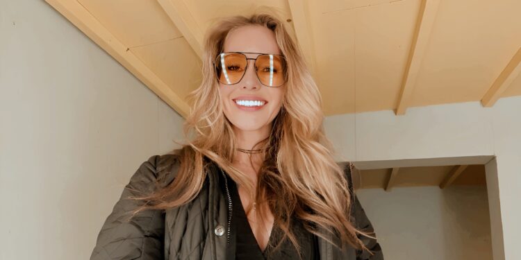 Elena Nozon, erfolgreiche Gründerin aus Hannover, lächelnd in ihrem Büro mit Laptop und Notizbuch